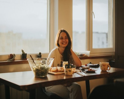 Mujer desayunando tranquilamente en su casa antes de ir a trabajar